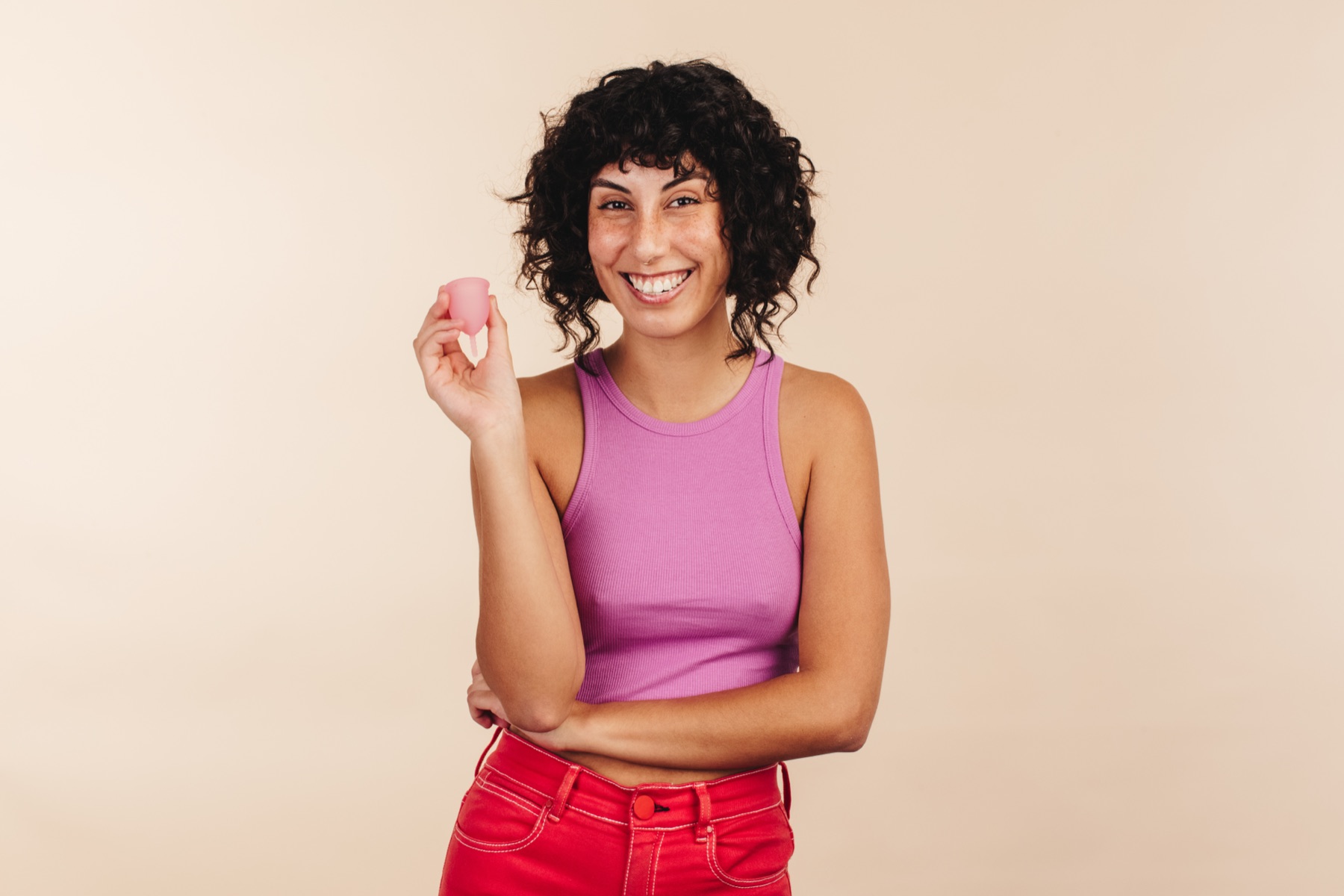 Carefree woman holding a reusable menstrual cup